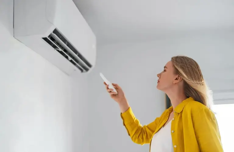 Chica encendiendo aire acondicionado en verano