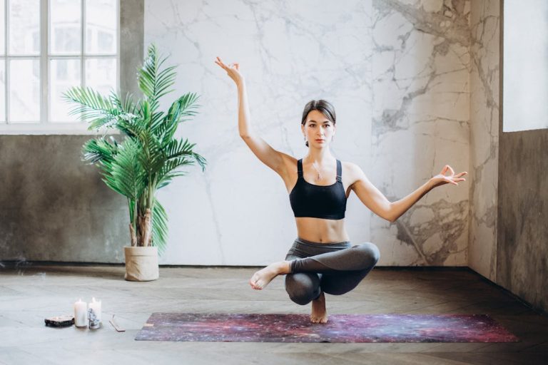 Yoga para principiantes: beneficios y primeras posturas para empezar hoy Mujer practicando yoga en casa sobre esterilla en postura de meditación
